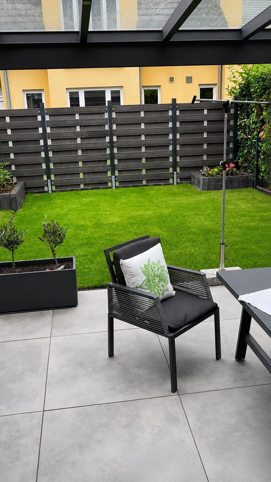 Neu gestaltete Terrasse mit gepflegtem Rasen und Sichtschutz