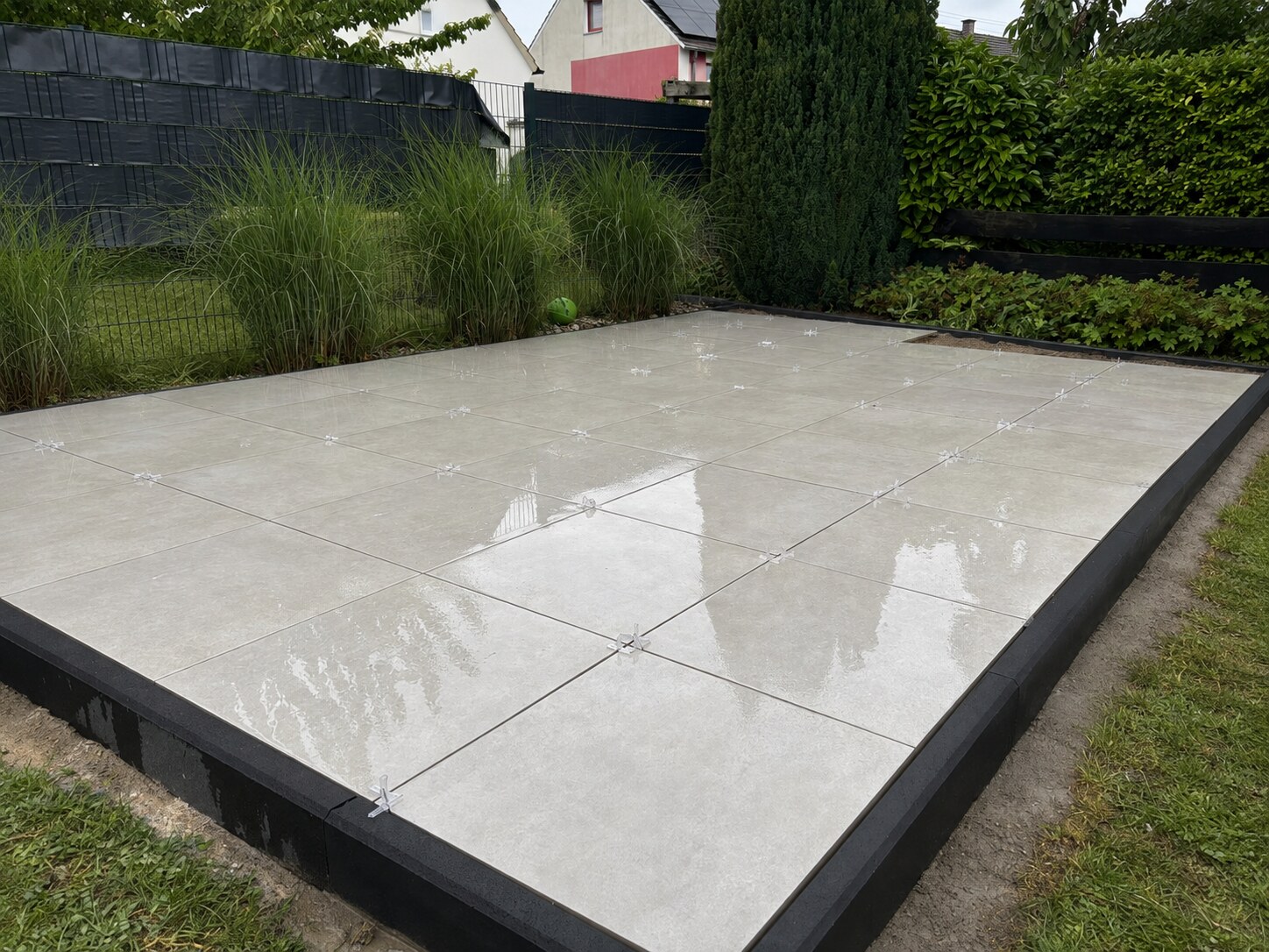 Helle Terrassenplatten mit Abstandshaltern während der Verlegung