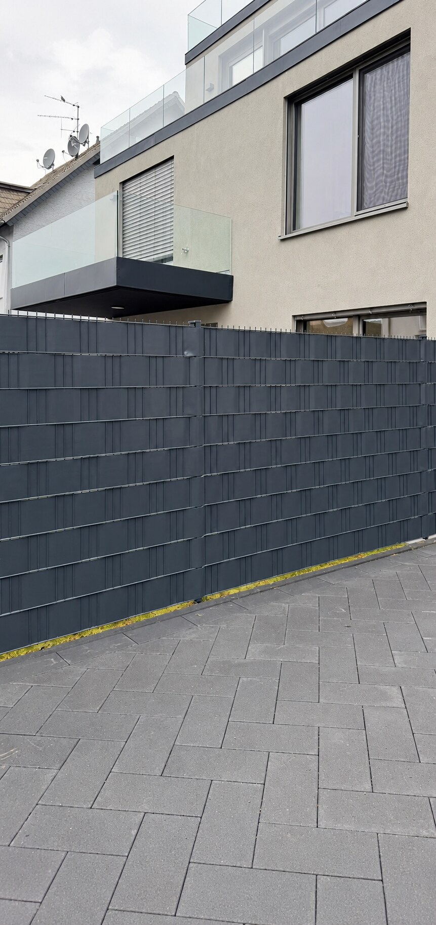 Anthrazitfarbener Zaun mit Sichtschutz an einem Wohnhaus